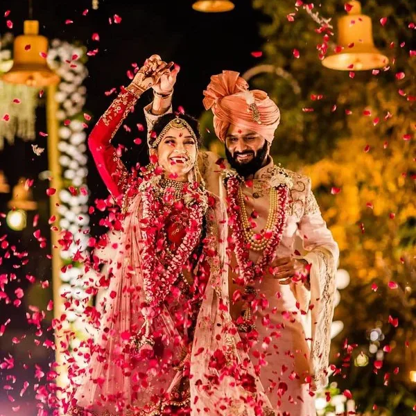 Traditional wedding attire with rose petal shower.