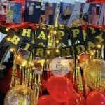 Elegant Car Dikki Birthday Decoration in Delhi NCR with red and gold balloons, fairy lights, and photo garland by Dream Spark Events