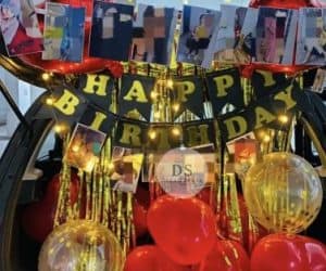Elegant Car Dikki Birthday Decoration in Delhi NCR with red and gold balloons, fairy lights, and photo garland by Dream Spark Events