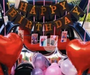 Premium Car Trunk Surprise Decoration in Delhi NCR with red and pink balloons, foil stars, and photo hangings by Dream Spark Events