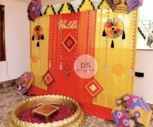 Stunning Grand Wedding Haldi Decor in Delhi NCR with marigold garlands and colorful umbrellas by Dream Spark Events