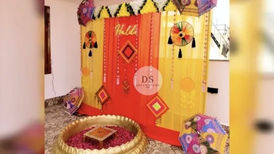 Stunning Grand Wedding Haldi Decor in Delhi NCR with marigold garlands and colorful umbrellas by Dream Spark Events