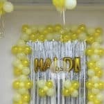 Vibrant Haldi Decoration in Delhi NCR featuring yellow and white balloons with a golden shimmer backdrop by Dream Spark Events