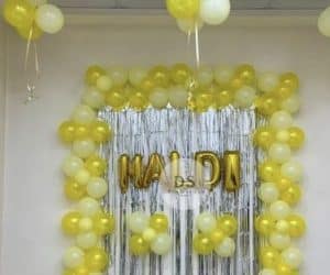 Vibrant Haldi Decoration in Delhi NCR featuring yellow and white balloons with a golden shimmer backdrop by Dream Spark Events