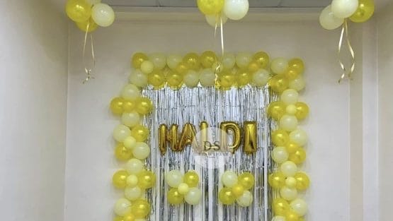 Vibrant Haldi Decoration in Delhi NCR featuring yellow and white balloons with a golden shimmer backdrop by Dream Spark Events