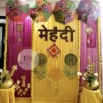 Golden Mehndi Night Decoration package with floral garlands and shimmer backdrop by Dream Spark Events