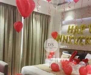 Romantic Anniversary Room Decoration Package featuring red heart balloons and golden Happy Anniversary backdrop by Dream Spark Events