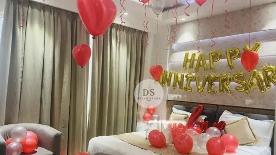 Romantic Anniversary Room Decoration Package featuring red heart balloons and golden Happy Anniversary backdrop by Dream Spark Events