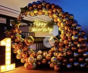 Beautiful First Anniversary Decoration in Delhi NCR featuring gold and silver balloon ring with neon light signage by Dream Spark Events